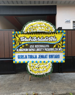 Papan Bunga Duka di Figur